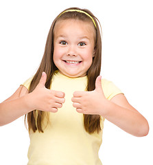 Image showing Little girl is showing thumb up gesture