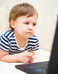 Image showing Little boy is playing on laptop