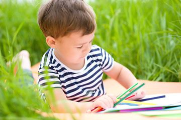 Image showing Little boy is playing with pencils