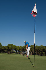 Image showing golf player hitting shot at sunny day