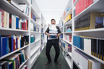 Image showing Student holding lot of books in school library