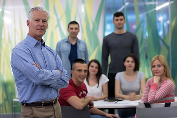 Image showing portrait of  teacher with students group in background