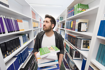 Image showing Student holding lot of books in school library