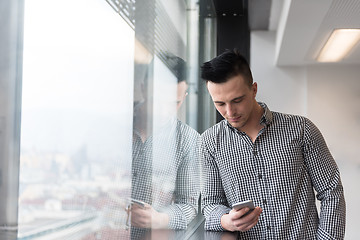 Image showing young business man using smart phone at office