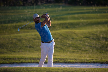 Image showing golfer hitting a sand bunker shot on sunset