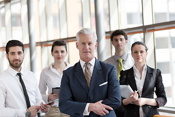 Image showing portrait of senior businessman as leader  with group of people i