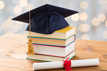 Image showing close up of books with diploma and mortarboard