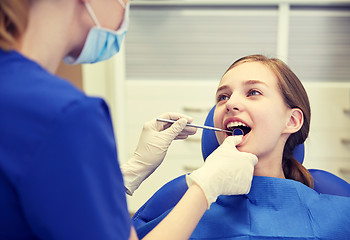 Image showing female dentist checking patient girl teeth