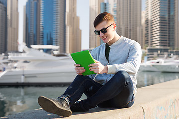 Image showing happy young man with tablet pc over city port