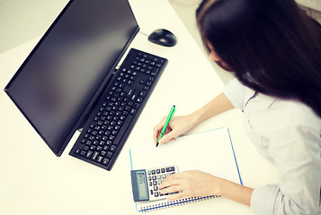 Image showing close up of woman with calculator counting