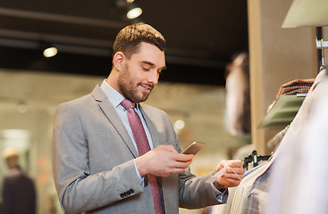 Image showing man in suit with smartphone at clothing store