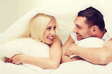 Image showing happy couple lying in bed and talking at home