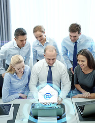 Image showing smiling business people with laptop in office