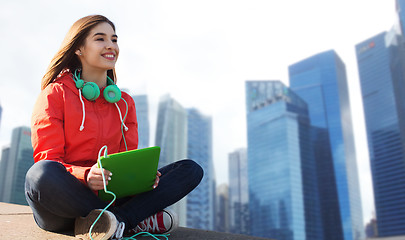 Image showing happy young woman with tablet pc and headphones