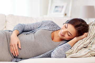 Image showing happy pregnant woman lying on sofa at home