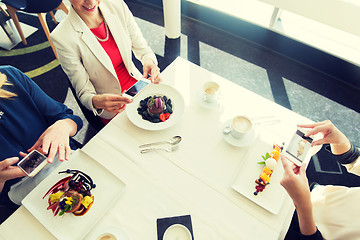 Image showing close up of women picturing food by smartphones