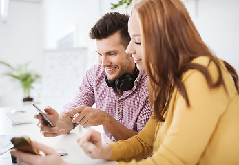 Image showing happy creative team with smartphones at office