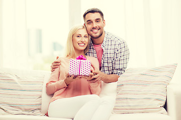 Image showing happy man giving woman gift box at home