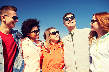 Image showing happy teenage friends in shades talking on street