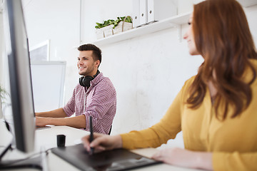 Image showing happy creative team with computer and pen tablet