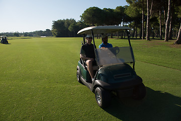 Image showing golf players driving cart at course