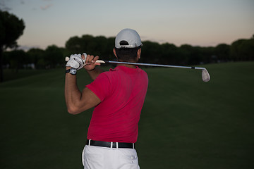 Image showing golfer hitting a sand bunker shot on sunset