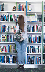 Image showing famale student selecting book to read in library