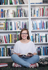 Image showing famale student reading book in library