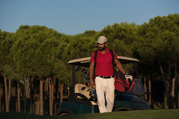 Image showing golfer  walking and carrying golf  bag