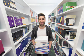 Image showing Student holding lot of books in school library