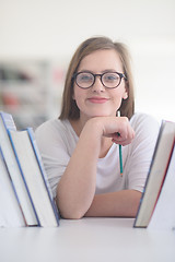 Image showing portrait of famale student selecting book to read in library