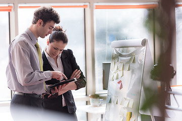 Image showing young couple working on flip board at office