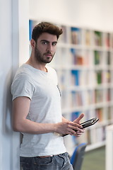 Image showing student in school library using tablet for research