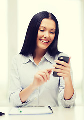 Image showing smiling businesswoman or student with smartphone
