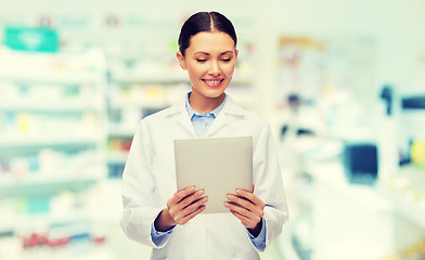 Image showing smiling female doctor with tablet pc at drugstore