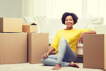 Image showing happy african woman with cardboard boxes at home