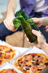 Image showing close up of male hands with beer and pizza at home