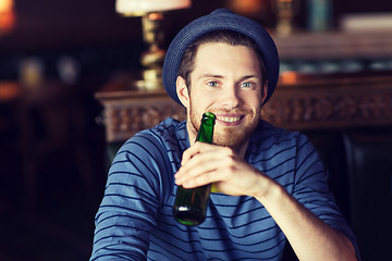 Image showing happy young man drinking beer at bar or pub