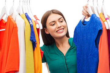 Image showing happy woman choosing clothes at home wardrobe