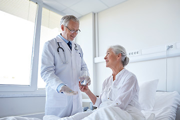 Image showing doctor giving medicine to senior woman at hospital