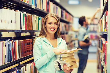 Image showing happy student girl or woman with book in library