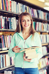 Image showing happy student girl or woman with book in library