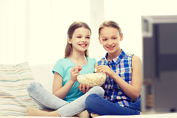 Image showing happy girls with popcorn watching tv at home