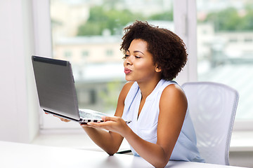 Image showing african woman sending kiss to laptop computer