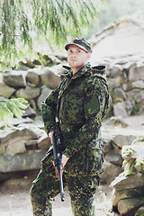 Image showing young soldier or hunter with gun in forest