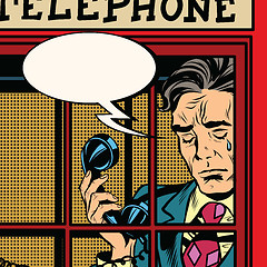 Image showing Retro man crying in the red phone booth