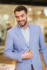 Image showing happy young man in jacket at clothing store