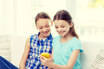 Image showing happy girls with smartphone sitting on sofa