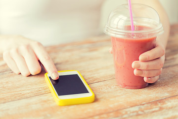 Image showing close up of woman with smartphone and smoothie