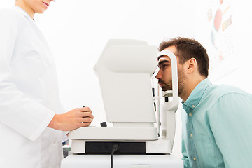 Image showing optician with autorefractor and patient at clinic